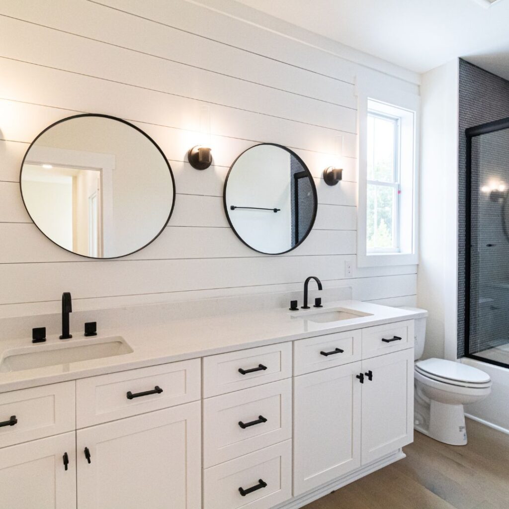 bathroom with wall sconces and natural light