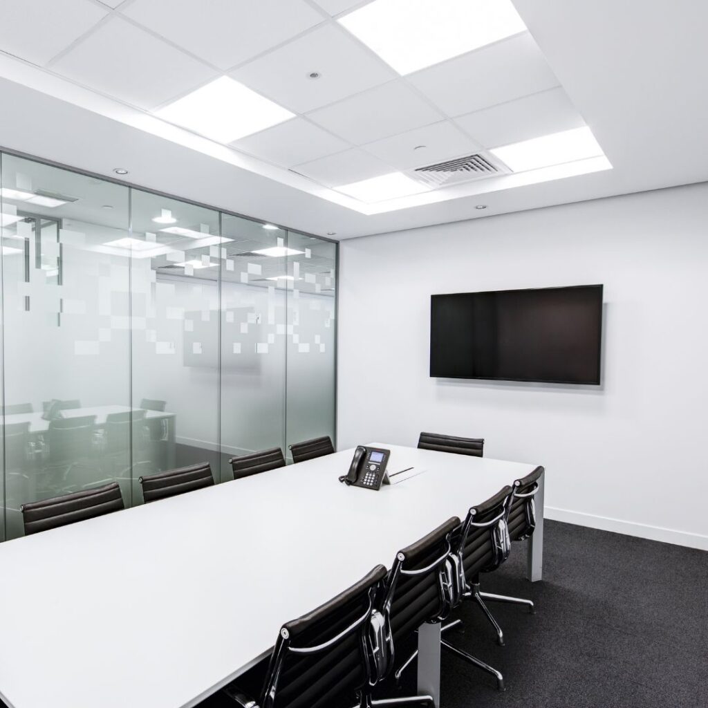 white conference room with tv screen and phone