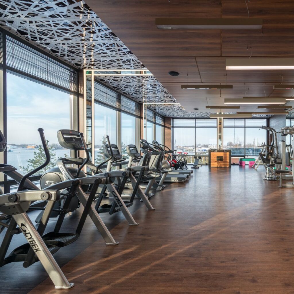 gym with hardwood floors, treadmills and large windows