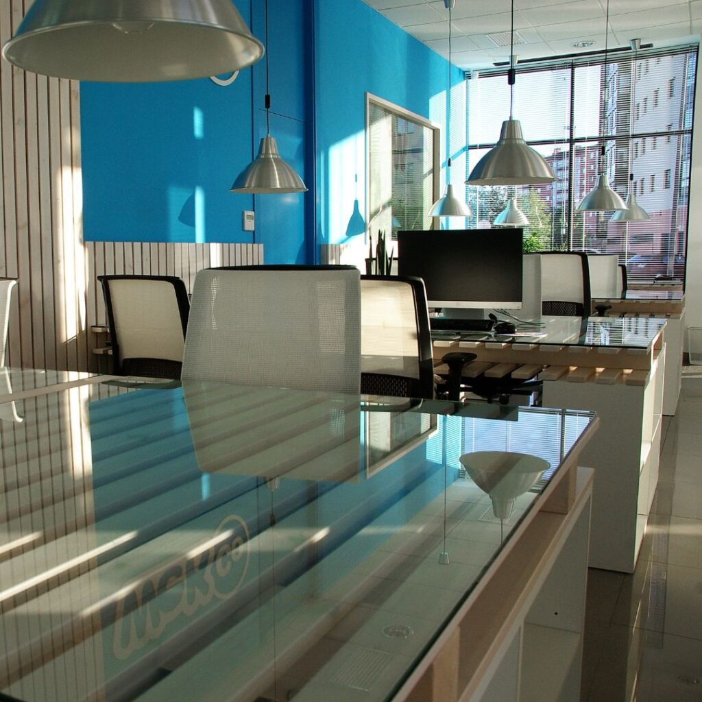 office with multiple desks with bright blue wall